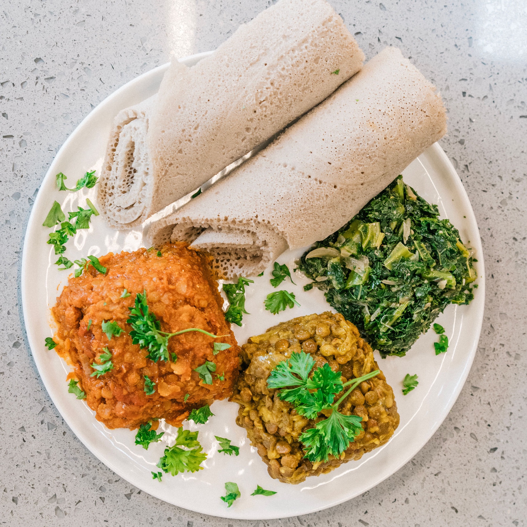 Injera served with colourful Ethiopian lentil and vegetable dishes